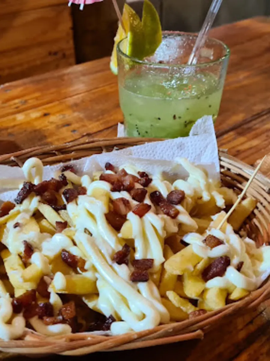 Cesta de batata frita coberta de cubos de bacon e fios de catupiry