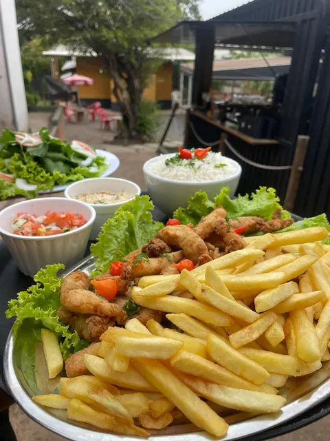 Travessa de iscas de tilápia empanadas com batata frita, arroz e vinagrete